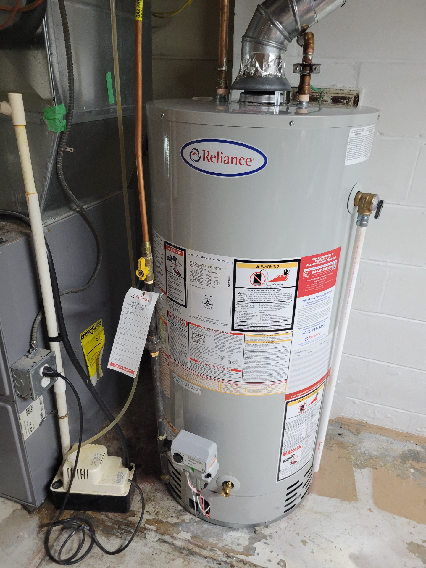 Reliance tank water heater installed beside a furnace