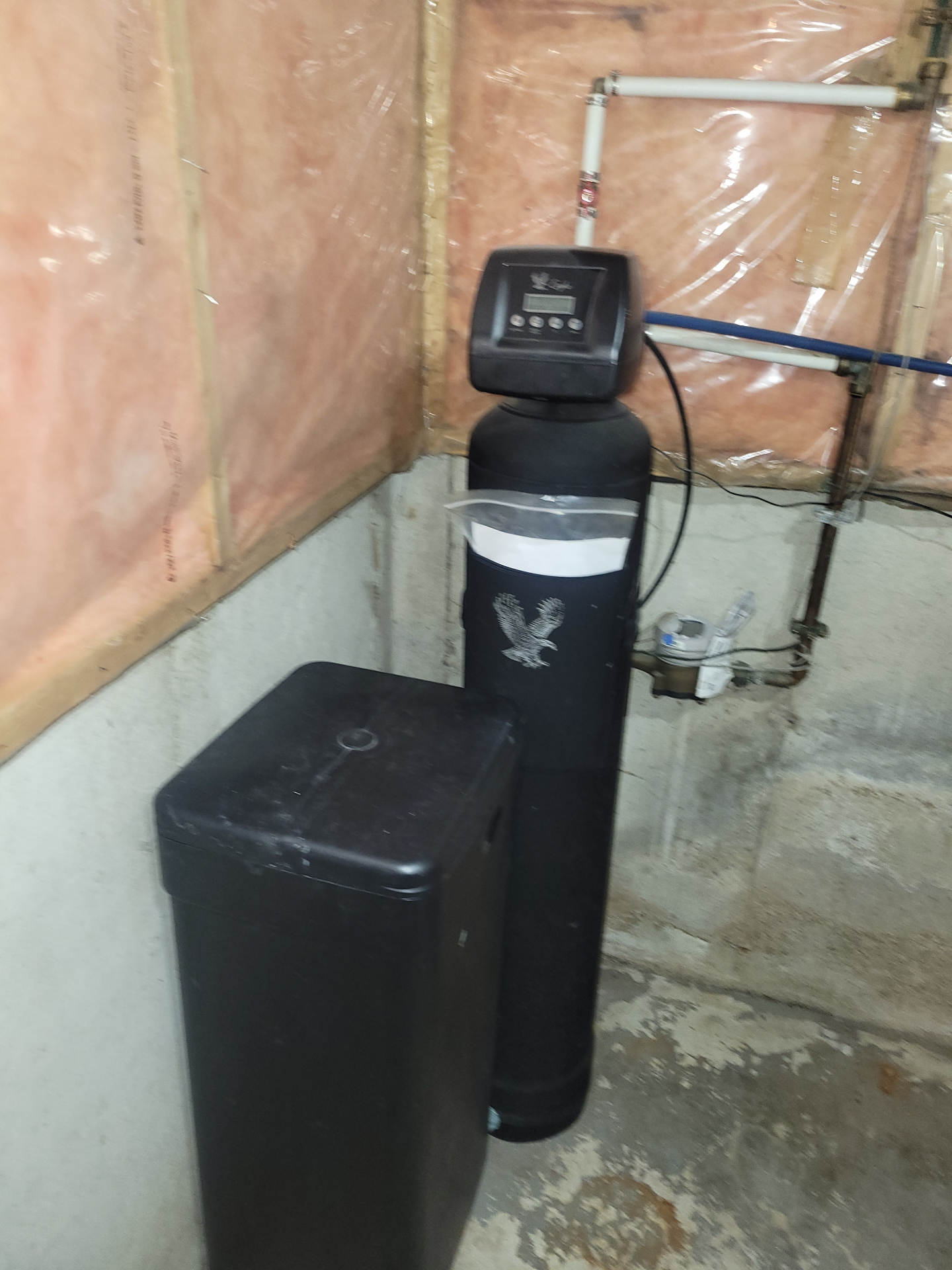 Black water softener and brine tank installed in a local home