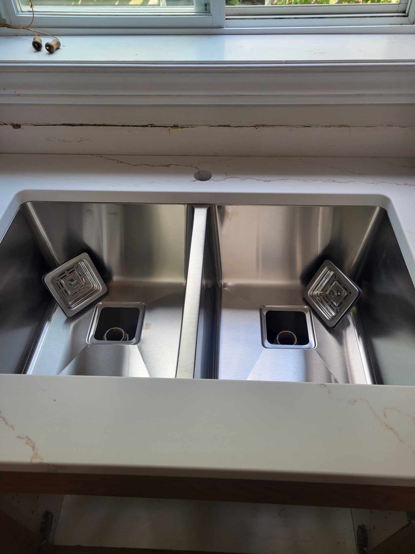 Double stainless sink prepared for new drain connections